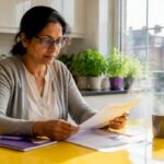 Homeowner reviewing domestic EPC document at kitchen table