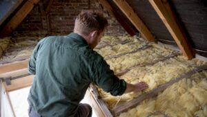 Assessor checking insulation in a London loft