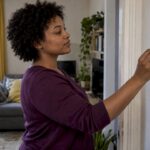 Resident lowering a London flat thermostat
