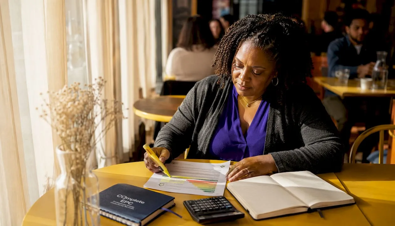 Woman reviewing energy certificate at home table