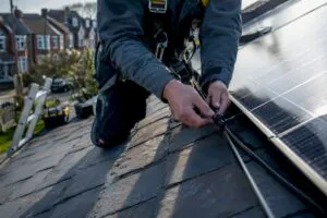 Technician wiring solar panels on roof