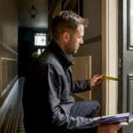 Energy assessor inspecting a UK home entrance
