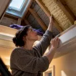 Homeowner checking loft insulation thickness
