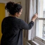 Landlord checking draught proofing around window