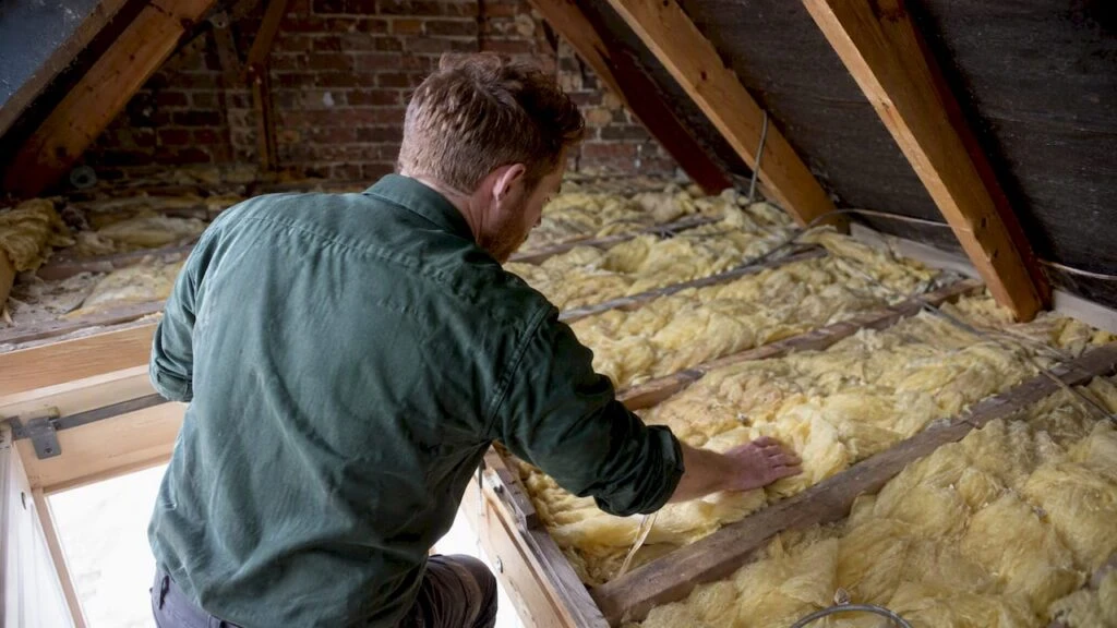 Assessor checking insulation in a London loft