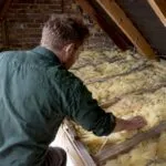 Assessor checking insulation in a London loft