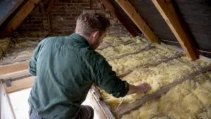 Assessor checking insulation in a London loft