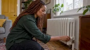 Homeowner adjusting a radiator valve