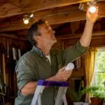 Man installing energy-efficient LED bulbs in kitchen